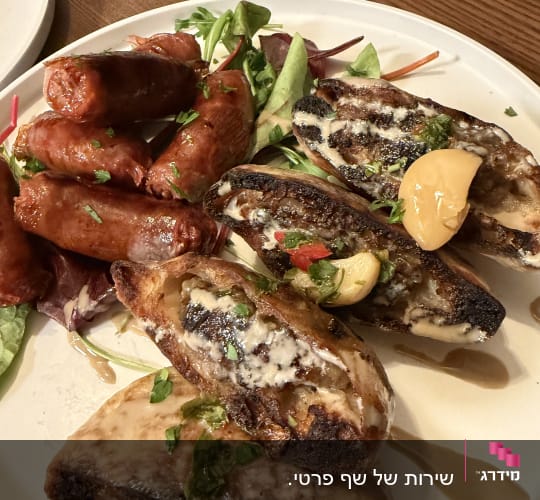 צלחת עם נקניקיות ולחם קלוי עם רוטב ועשבי תיבול